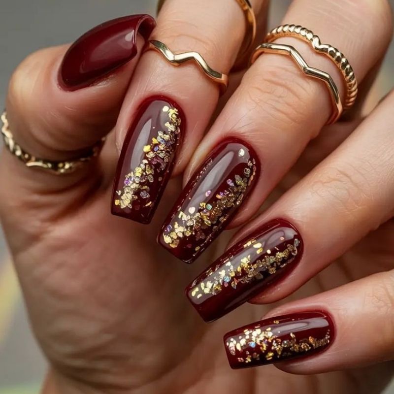 deep burgundy wine red christmas nails with matte finish and gold leaf accent coffin shape