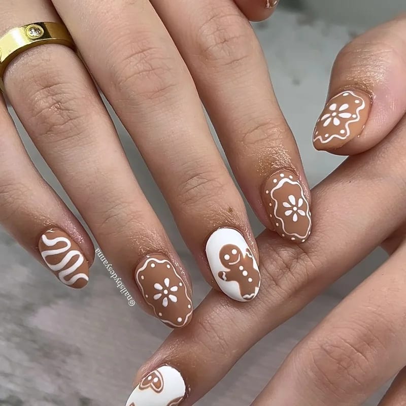 Gingerbread man nail design with brown base and white icing decorative details