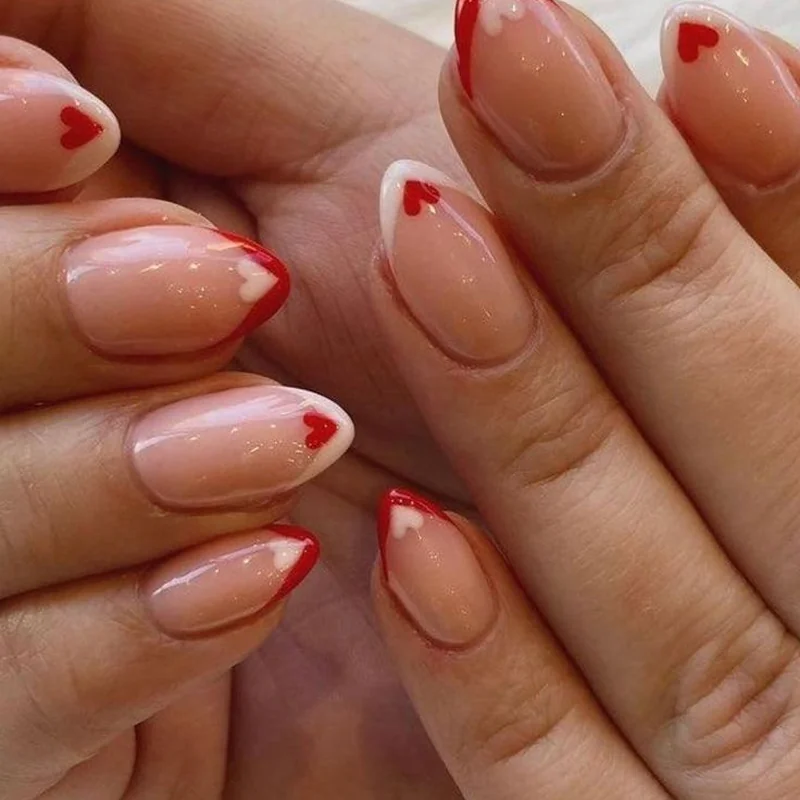 French tips with small heart accents showing balanced nail art placement