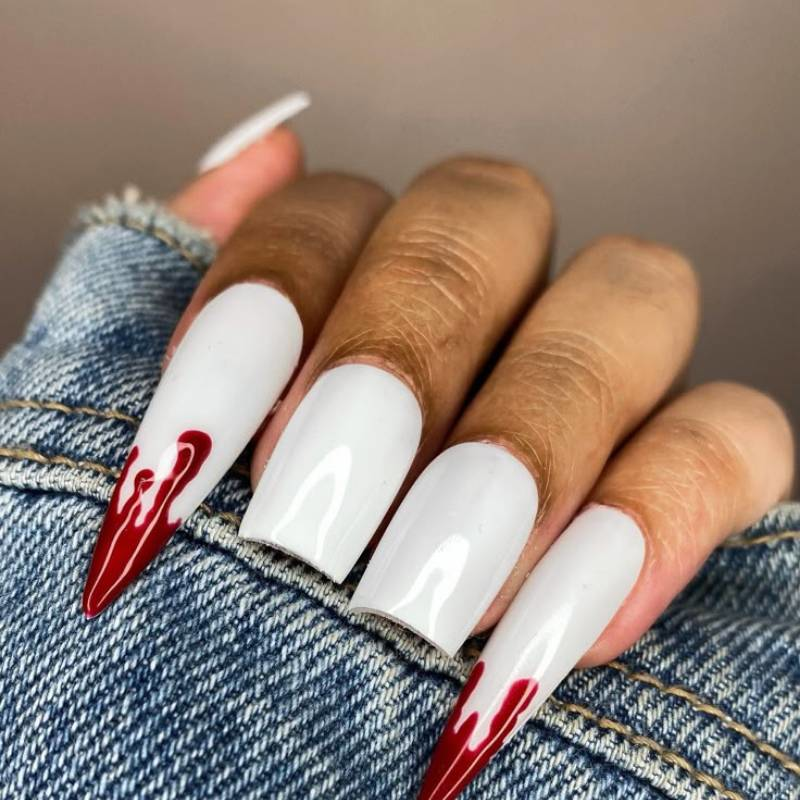 Stiletto vampire nails with fang accents and red polish