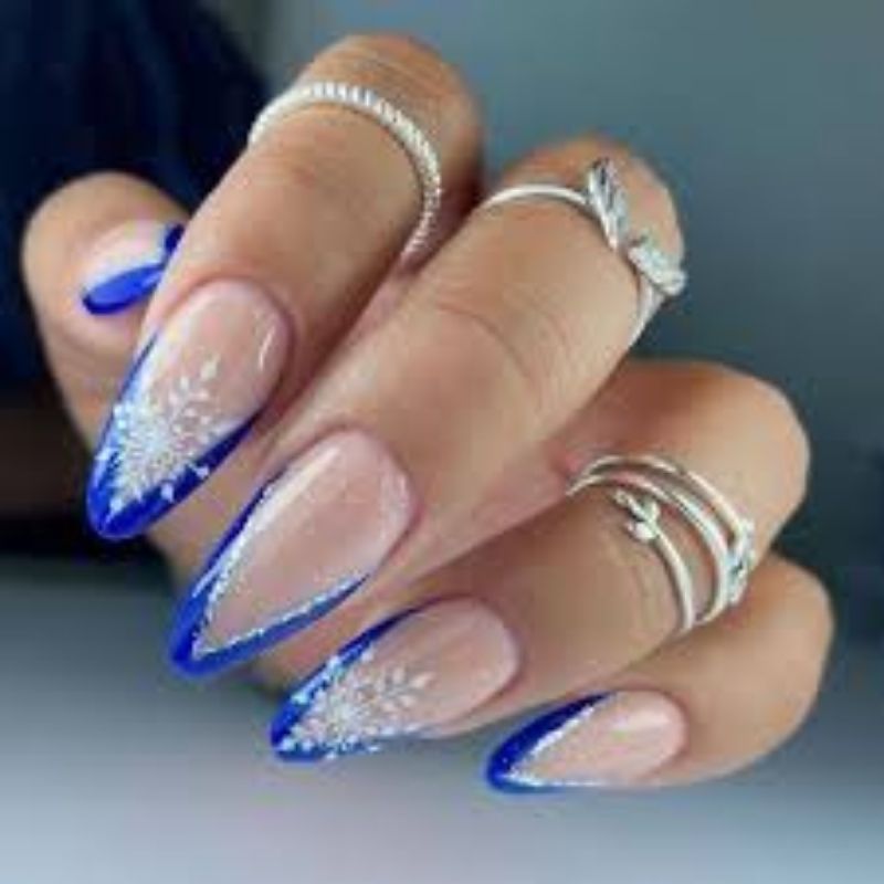 white christmas nails with hand painted blue snowflakes on almond shape winter wonderland nail art design