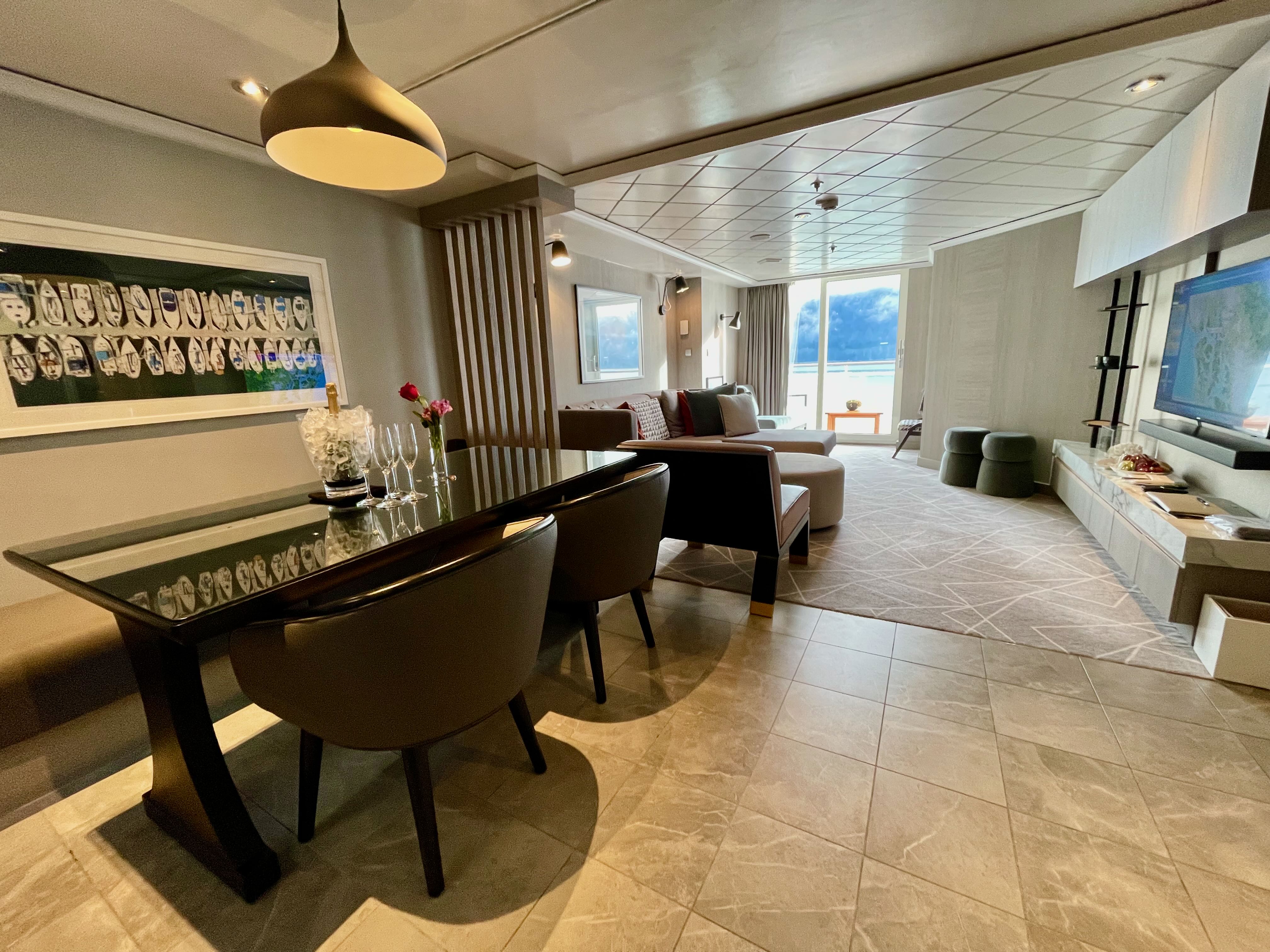 Royal Suite living room with champagne, roses, and Alaska mountains through floor-to-ceiling windows
