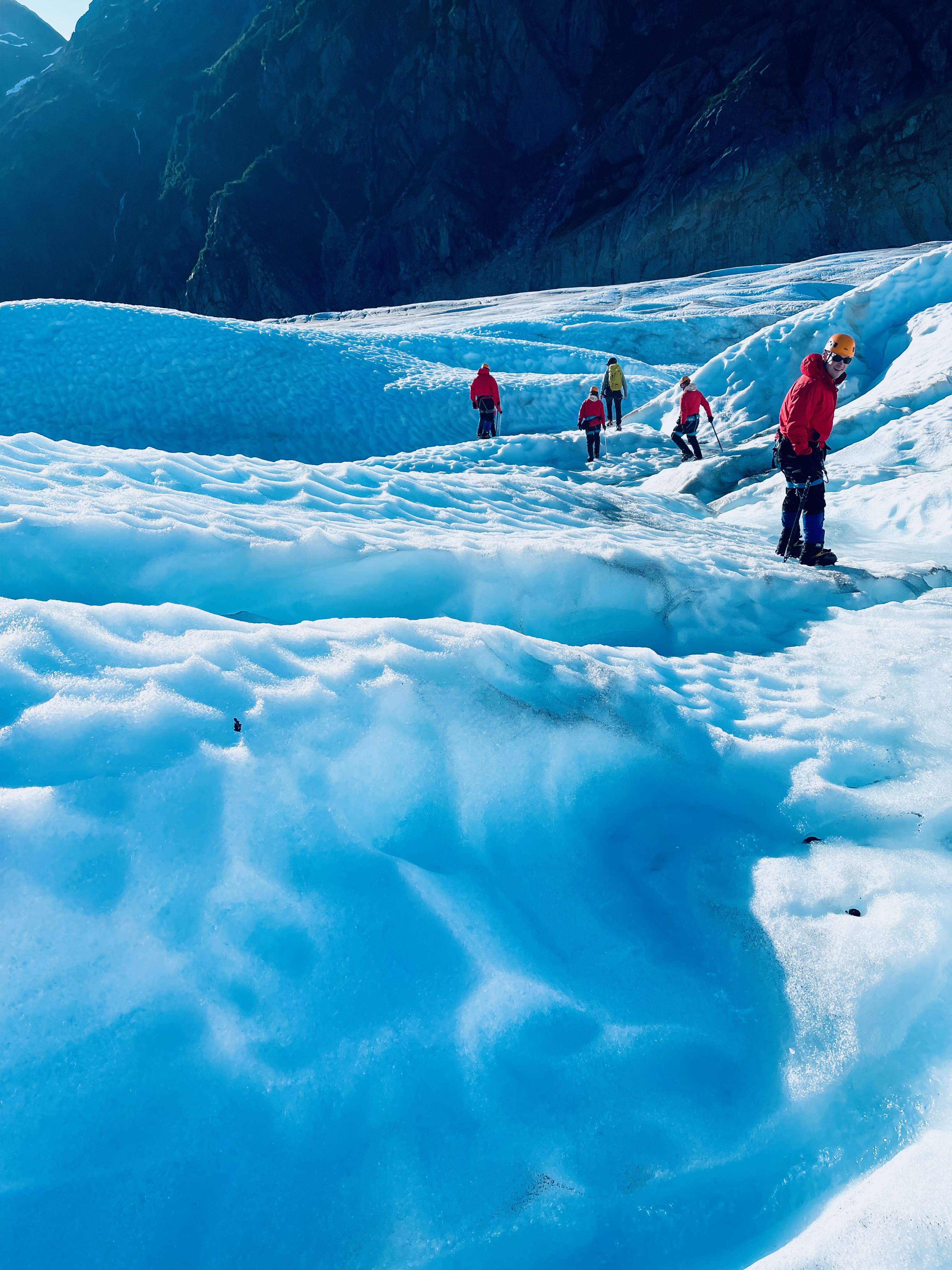 Full group in motion across the glacier ice