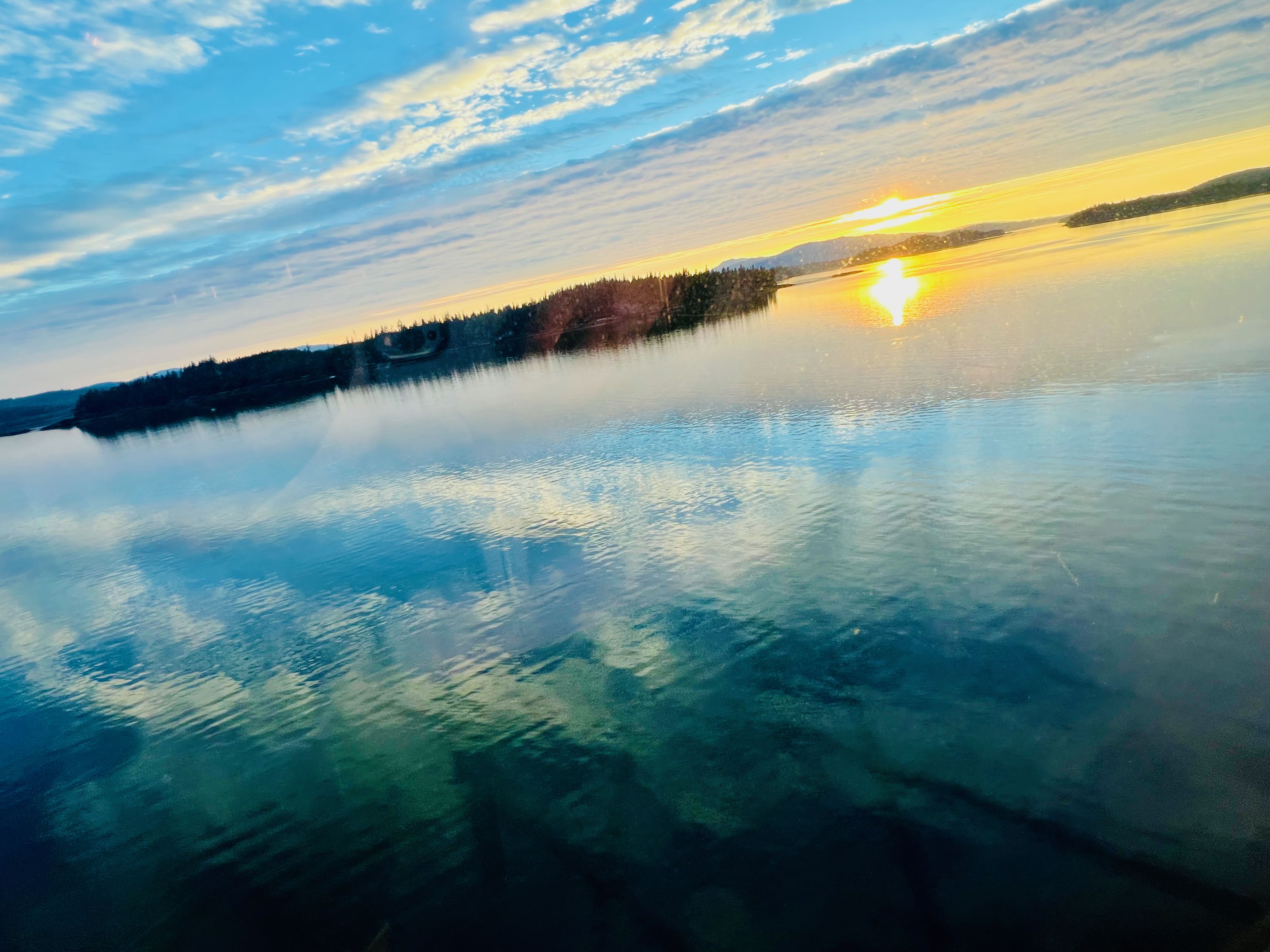 Wide glacier landscape with crevasse wall and tiny trekkers in the distance