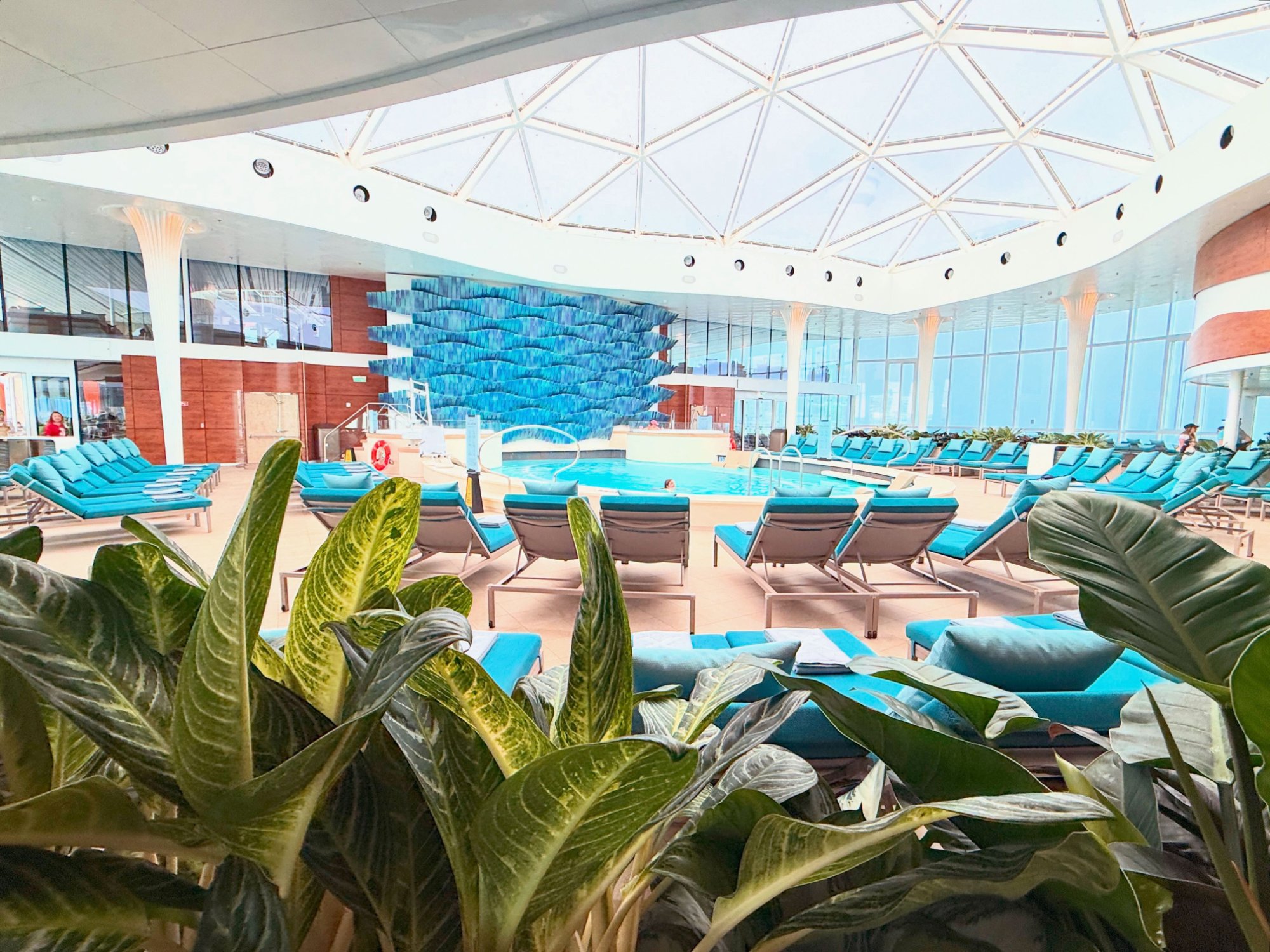 AquaSpa Solarium on Celebrity Xcel — geodesic glass dome, teal loungers, blue wave art wall