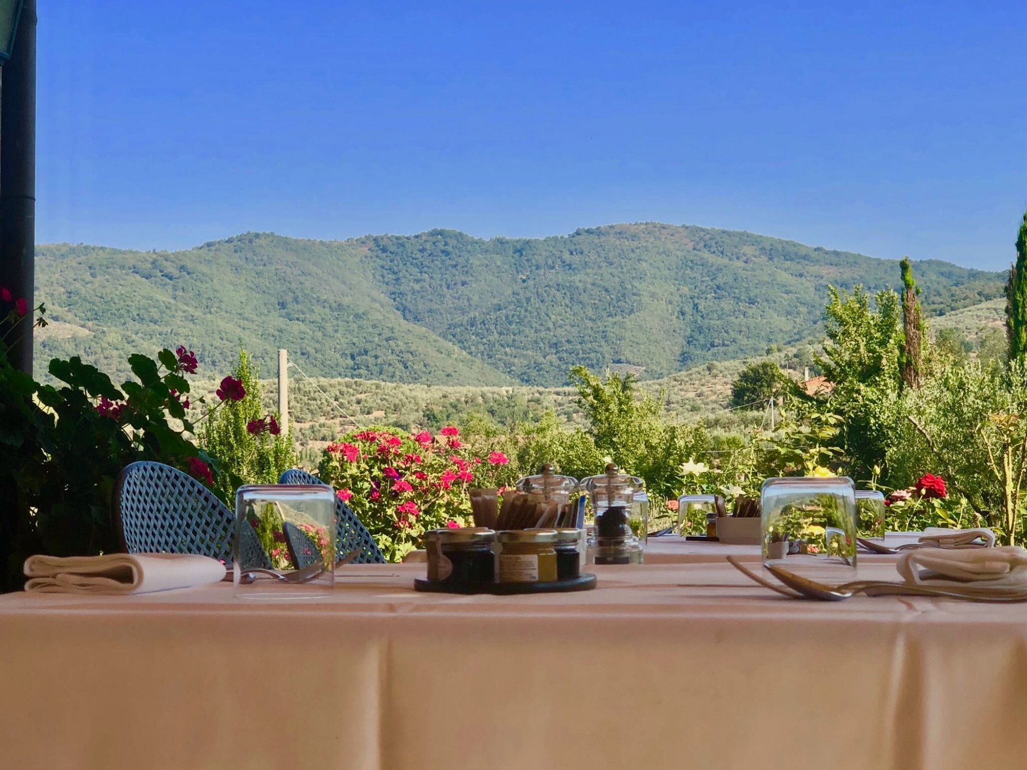 Breakfast table set with Tuscan hill views at Casa Portagioia