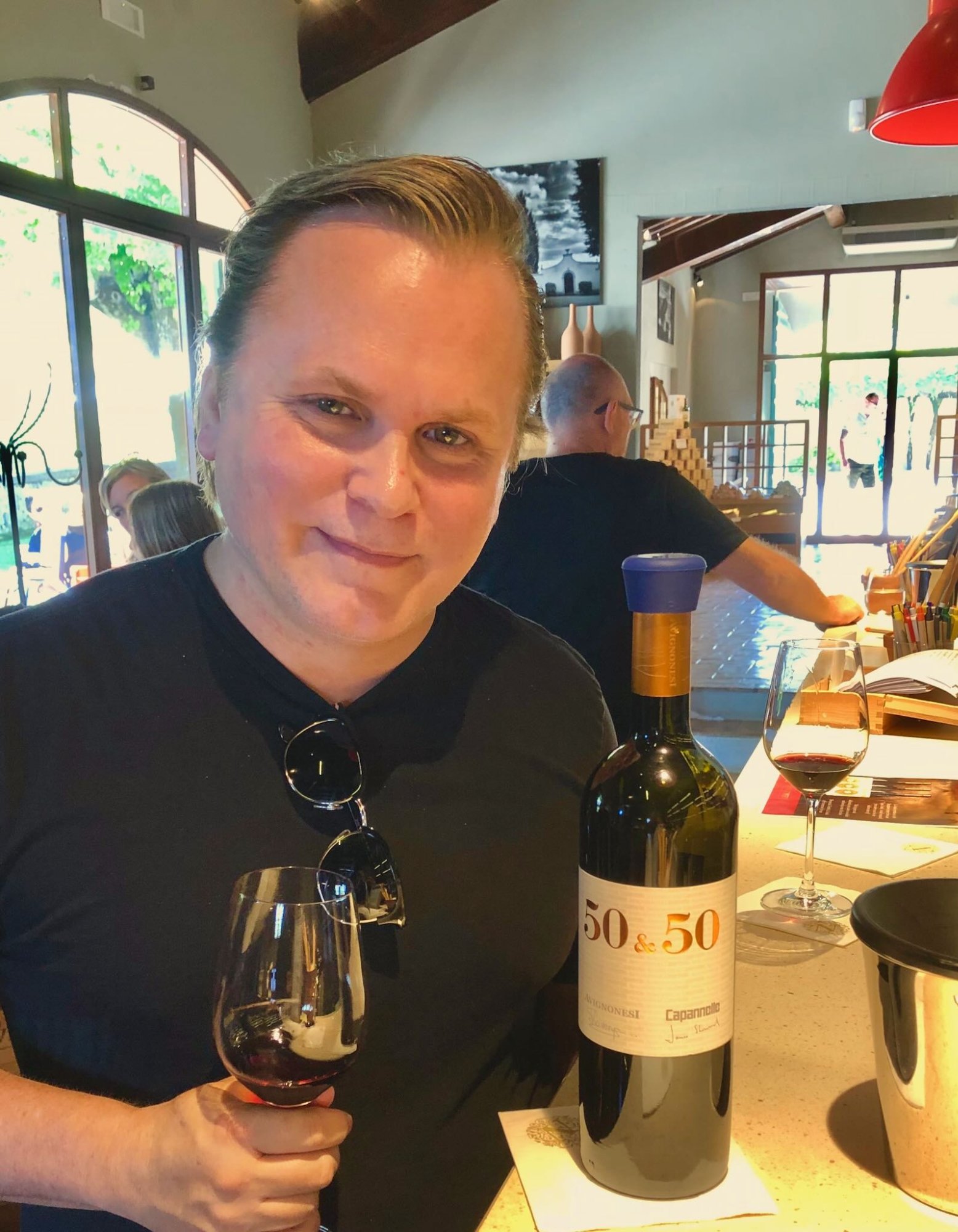 Patrick Raymond holding a glass of the Avignonesi-Capannelle 50&50 at the tasting bar