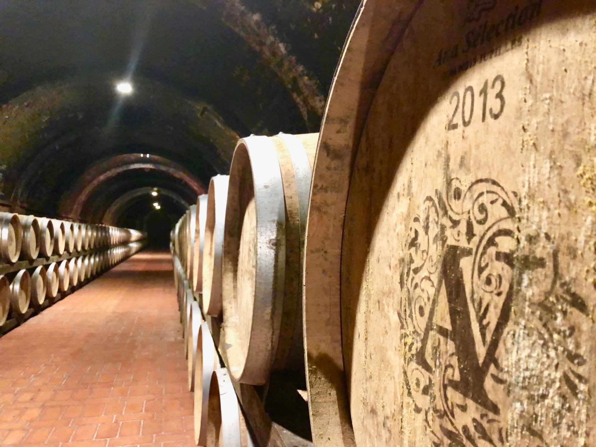 Avignonesi barrel cave tunnel stretching into darkness with oak casks from 2013