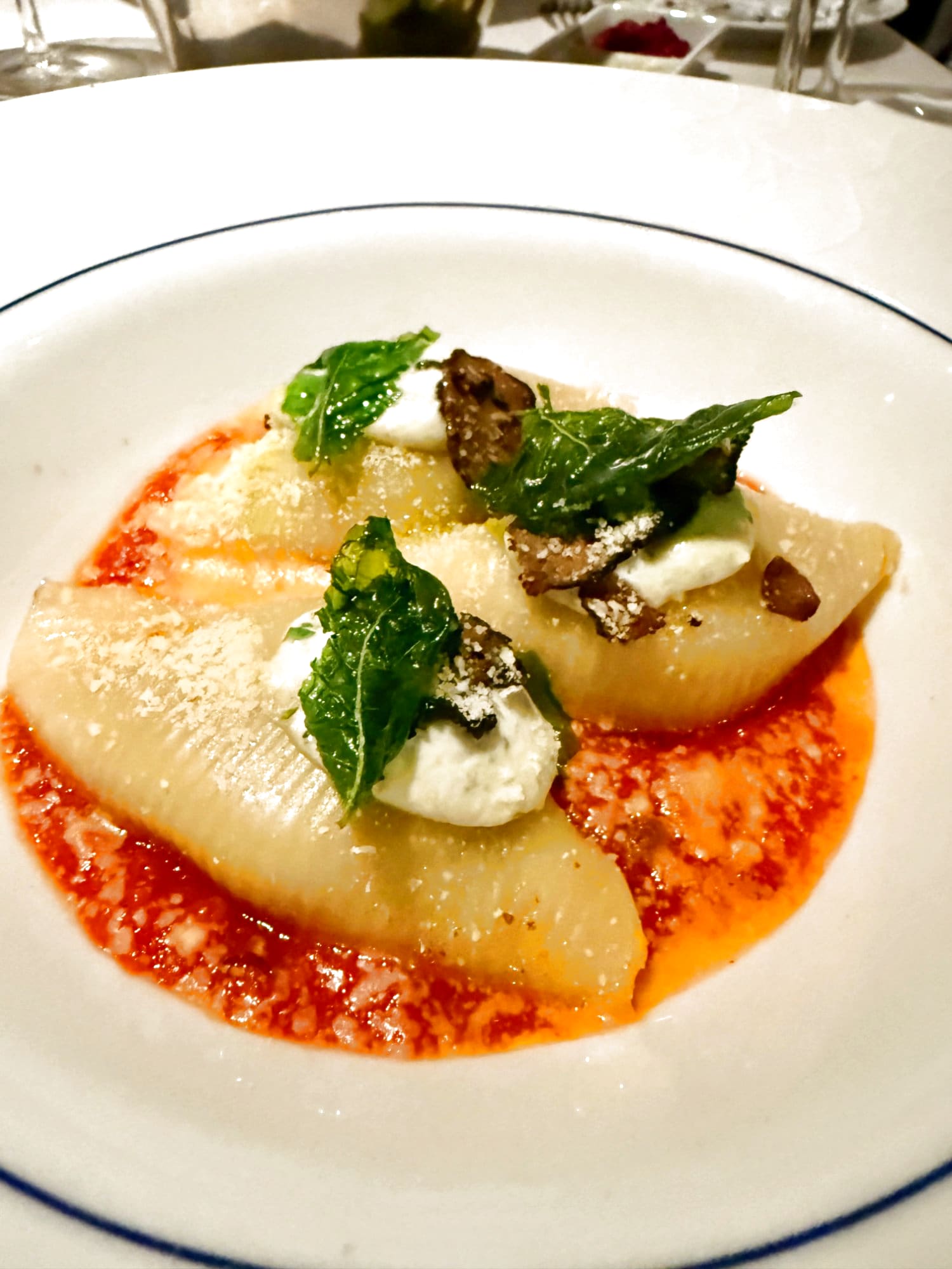 Blu stuffed pasta shells with truffle, tomato sauce, and crispy basil