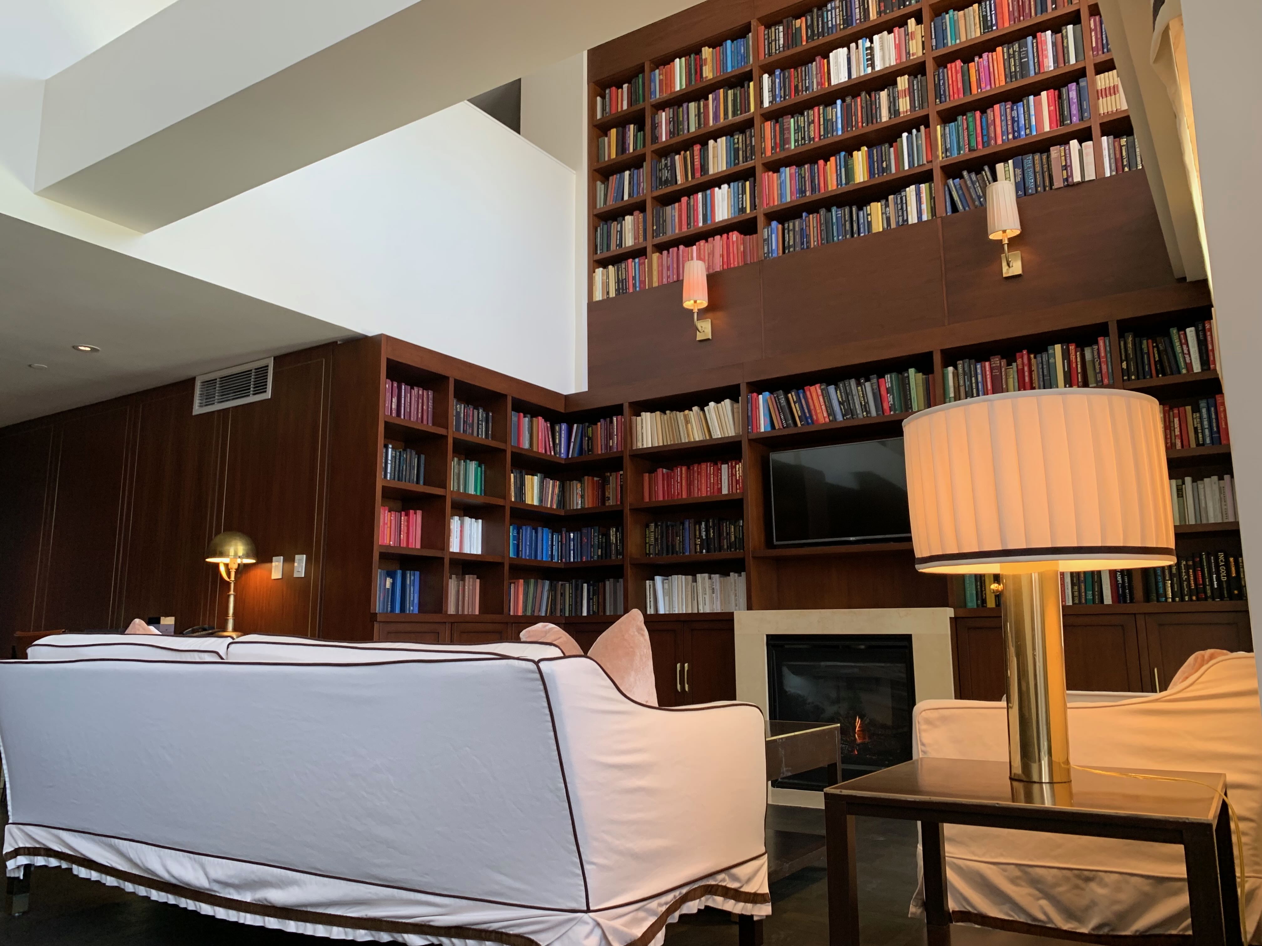 Sunset Tower townhouse — living room with loft floor-to-ceiling library
