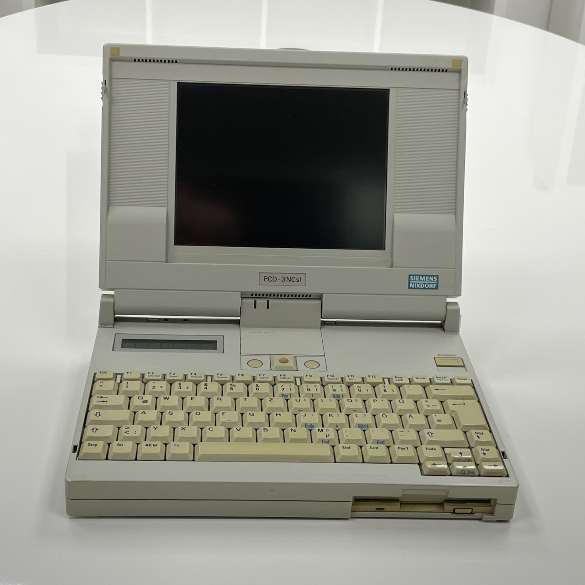 The Siemens-Nixdorf PCD-3NCsl, introduced in the early 1990s, was a compact business notebook featuring a 16 or 20 MHz Intel 80386SX processor, 2–4 MB RAM, and an 8-inch monochrome VGA LCD. It typically came with an 80 MB hard drive and a 1.44 MB floppy drive, and was rebranded by various companies, including RM (NB300), Packard Bell (386NB), and ICL (NB386s). Notably, it utilized a Dallas RTC chip for BIOS settings and had limited BIOS support for hard drive sizes, which can pose challenges when upgrading to modern storage solutions.