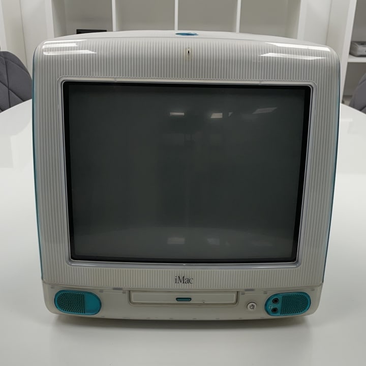 The iMac G3, introduced by Apple in 1998, was a groundbreaking all-in-one desktop computer that combined a 15-inch CRT display with the system's components in a single, translucent, and colorful enclosure. Initially released in "Bondi Blue," the iMac G3 later became available in various vibrant colors, such as Blueberry, Grape, Lime, Tangerine, and Strawberry. It featured a 233 MHz PowerPC G3 processor, 32 MB of RAM, a 4 GB hard drive, and notably eliminated the floppy disk drive in favor of USB ports, marking a significant shift in personal computer design and functionality.