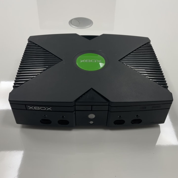 The original Xbox, released by Microsoft in 2001, is the company’s first gaming console, known for its powerful hardware, built-in hard drive, and popular titles like Halo: Combat Evolved. It introduced Xbox Live, pioneering online multiplayer gaming on consoles.