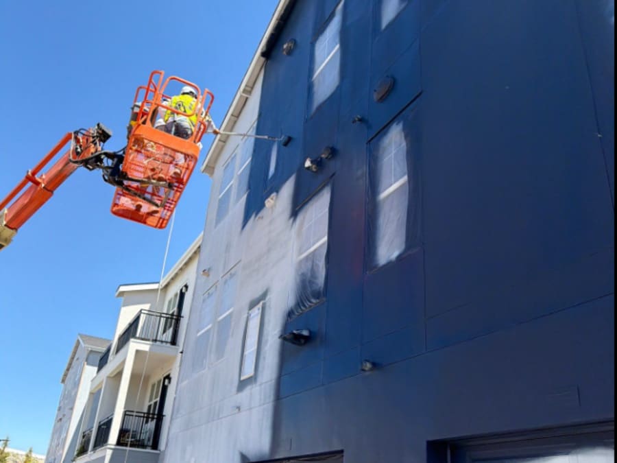 Exterior painting in progress from a boom lift at Inova Apartments, Reno, NV