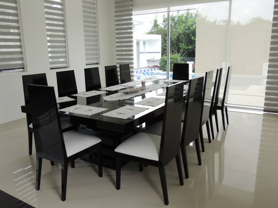 El comedor con mesa larga para diez, junto a los ventanales del jardín.