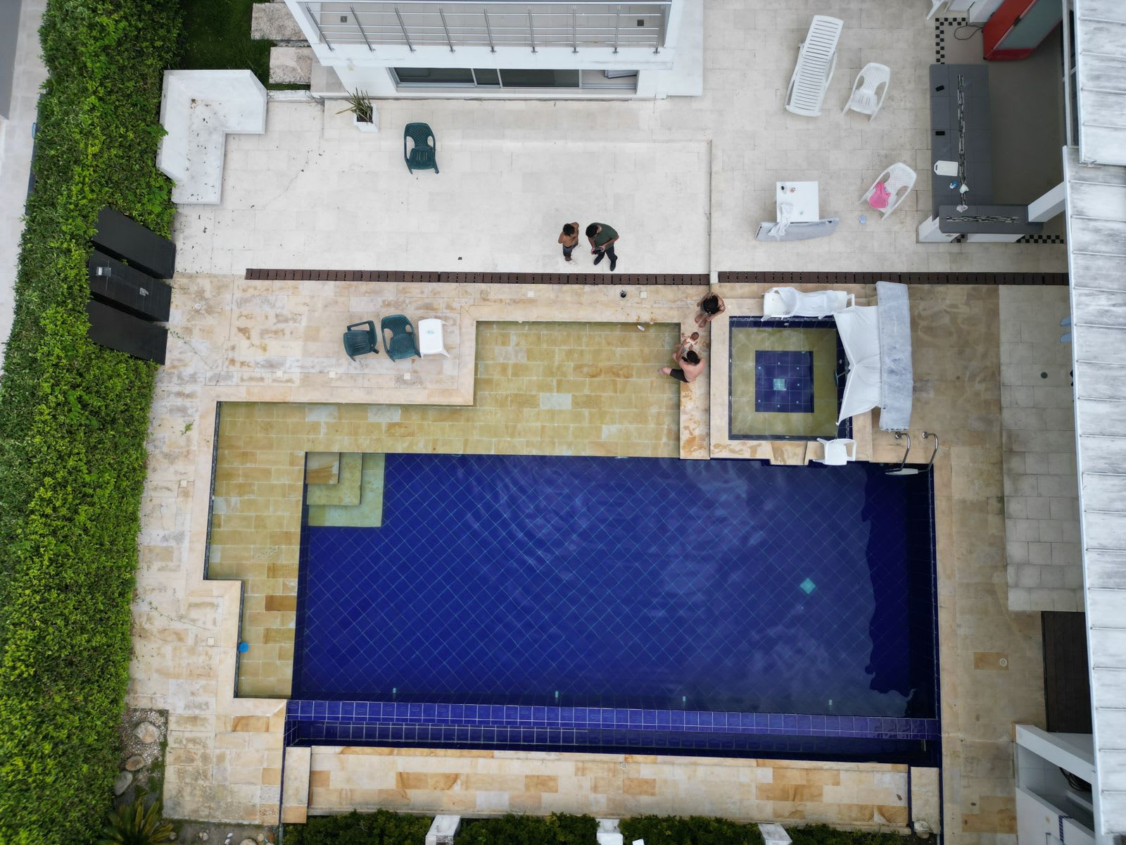 Vista aérea de la piscina y el patio empedrado que organizan toda la casa.