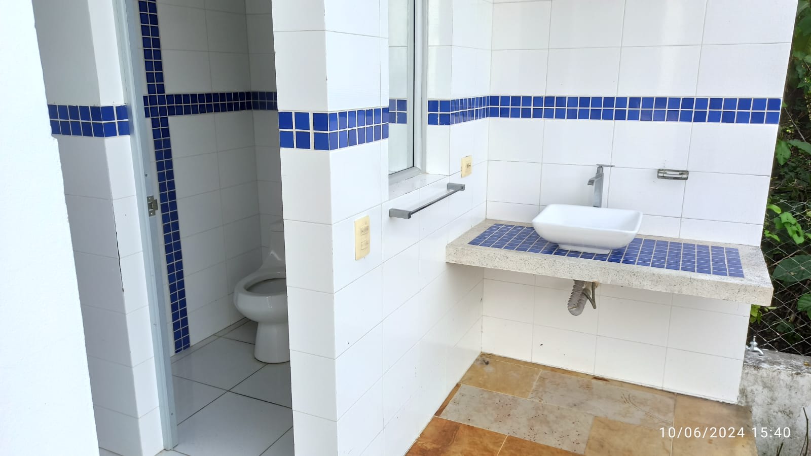 Baño con detalles en mosaico azul, sencillo y luminoso.