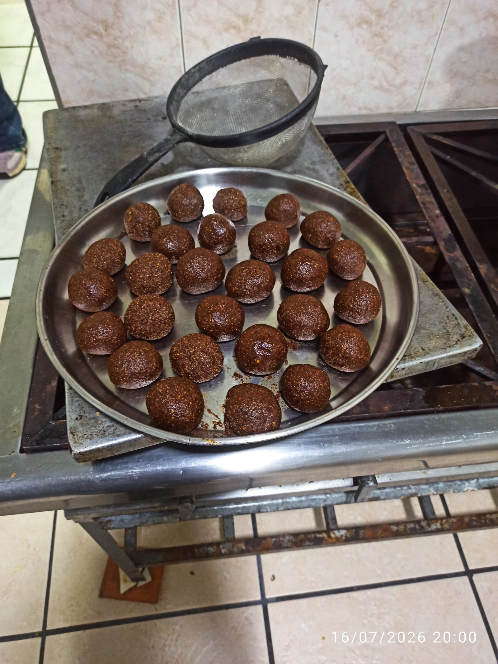 Bandeja de bolas de chucula terminadas junto al colador usado para cernir la harina.