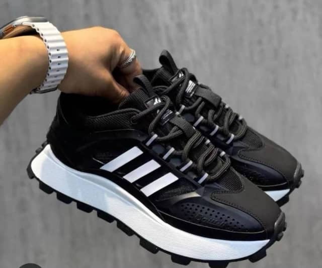 Baskets de sport Adidas noires et blanches à semelle crantée