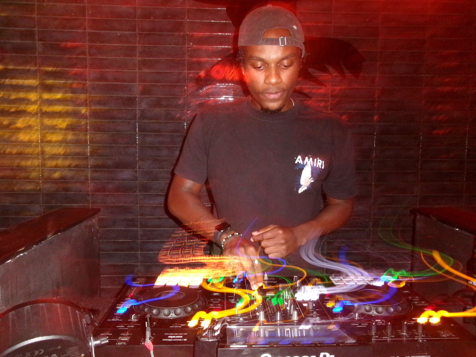 DJ Challenge preparing a DJ set in a dimly lit booth.