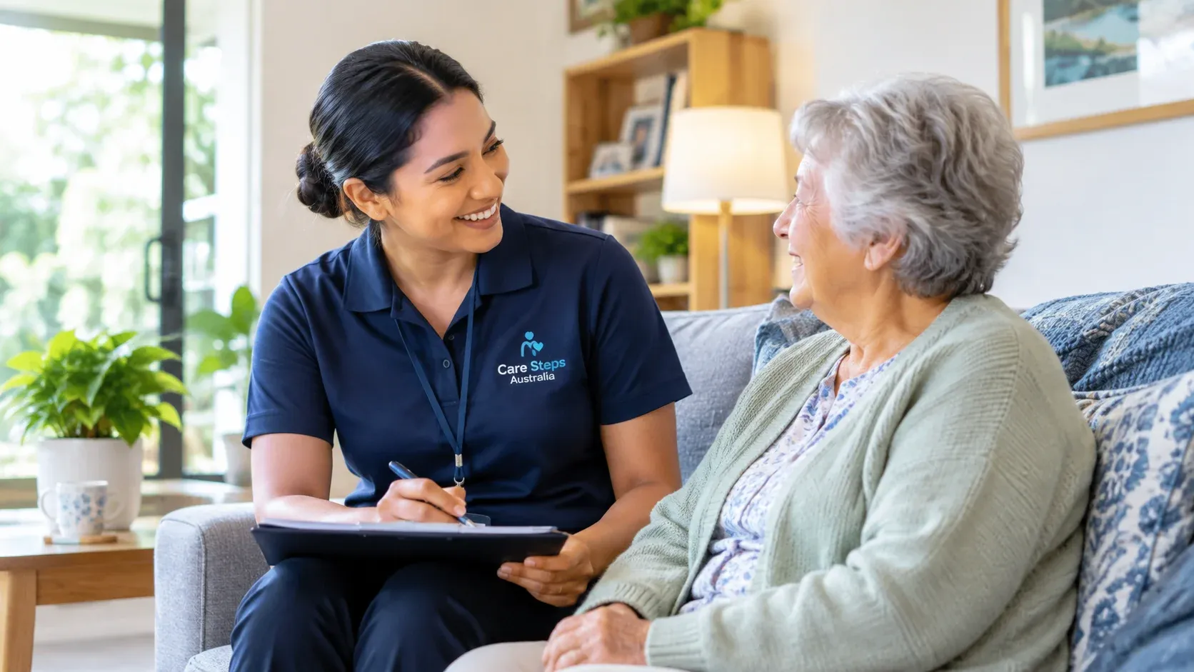 Care Steps Australia caregiver discussing Support at Home services with an older woman in her home.