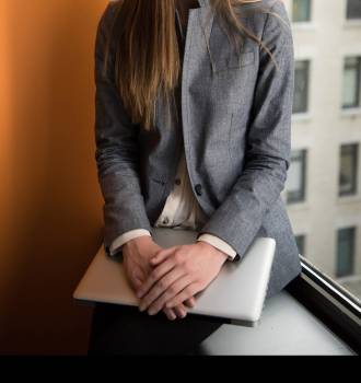 Woman sitting at window holding a laptop