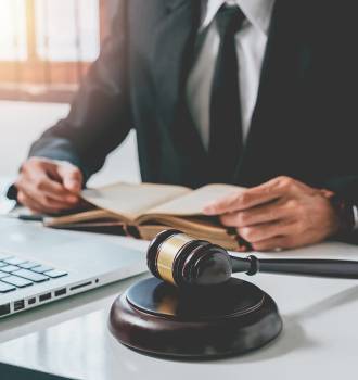 Attorney at his desk with computer, gavel, and scales of justice