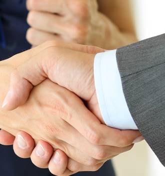 Man in a suit shaking hands with a woman