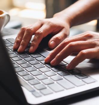 Close up of hands typing on a laptop