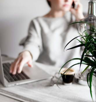 Woman sitting at her computer and on the phone