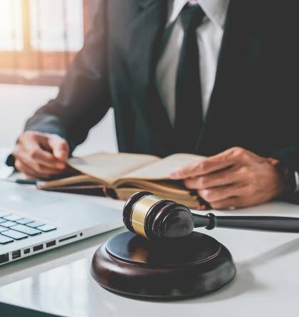 Attorney at his desk with computer, gavel, and scales of justice