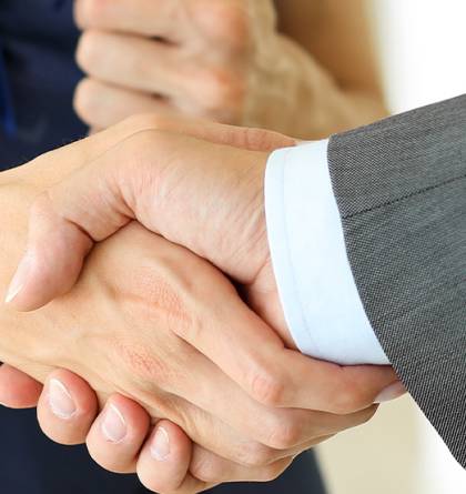 Man in a suit shaking hands with a woman