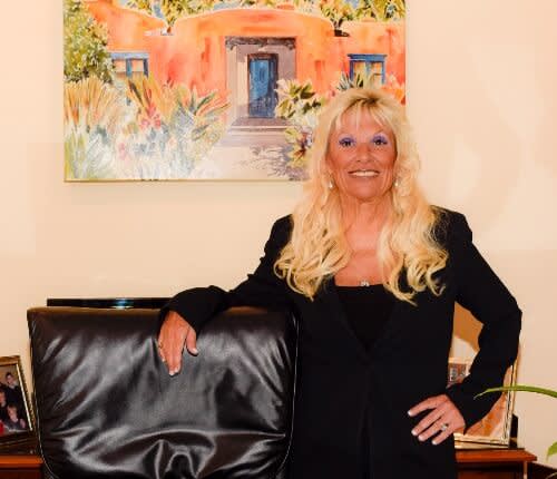 Susan Schauf standing at desk smiling