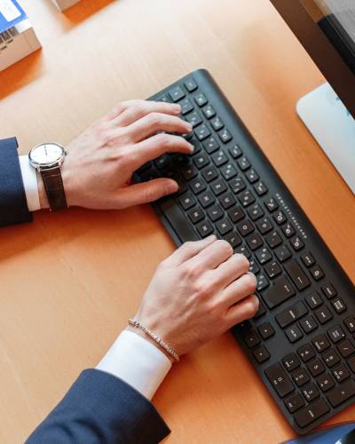 Man typing on a keyboard on a desk