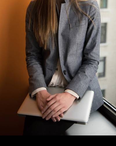 Woman sitting at window holding a laptop