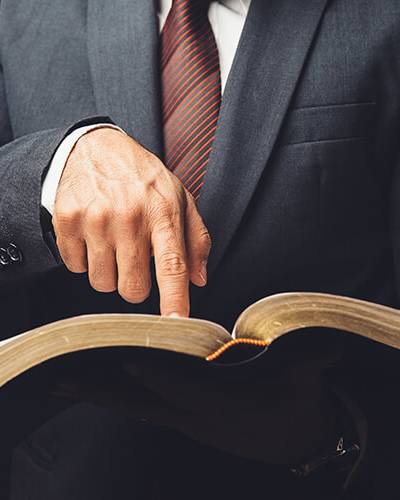 Man in suit pointing to a page in an open book