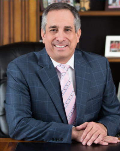 Attorney Gene sitting at his desk smiling