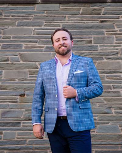 Alex standing outside in a suit