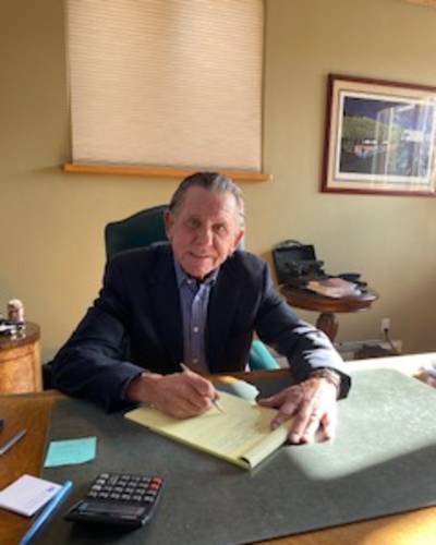 Dan Bowen writing on a legal pad at a desk