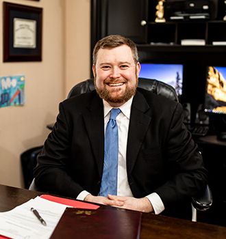 Hunter Morris Sitting at His Desk Smiling