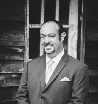 Attorney Benjamin D. Brubaker standing with his hands folded