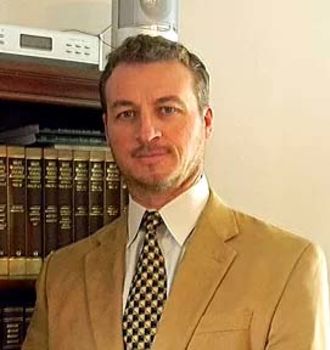 Dion J. Custis standing in front of a book case