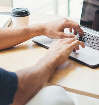 Man typing on a computer and working at a desk