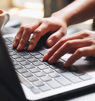 Close up of hands typing on a laptop