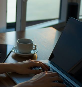 Woman working on a laptop with coffee