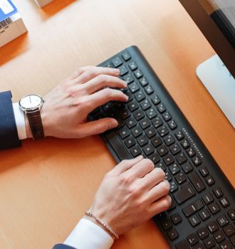 Man typing on a keyboard on a desk
