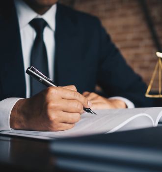 Lawyer in a suit writing at his desk