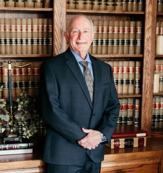 Dane Shields headshot in front of a bookcase