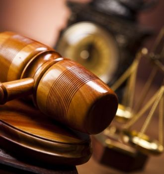 Gavel with scales of justice and old fashioned clock in the background