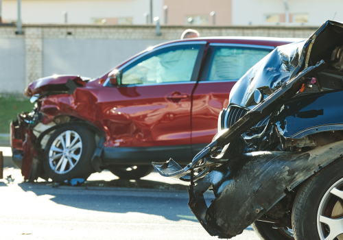 A car wreck between a red SUV and black car.